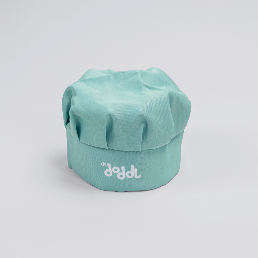 Turquoise chef's hat with 'doddl' branding on a light gray background