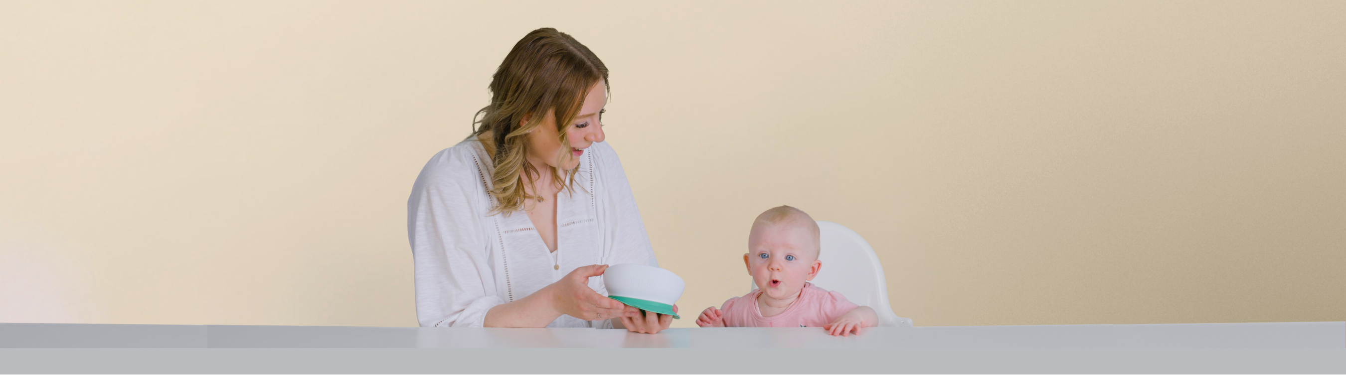 Woman and baby sittingat the table using doddl bowl